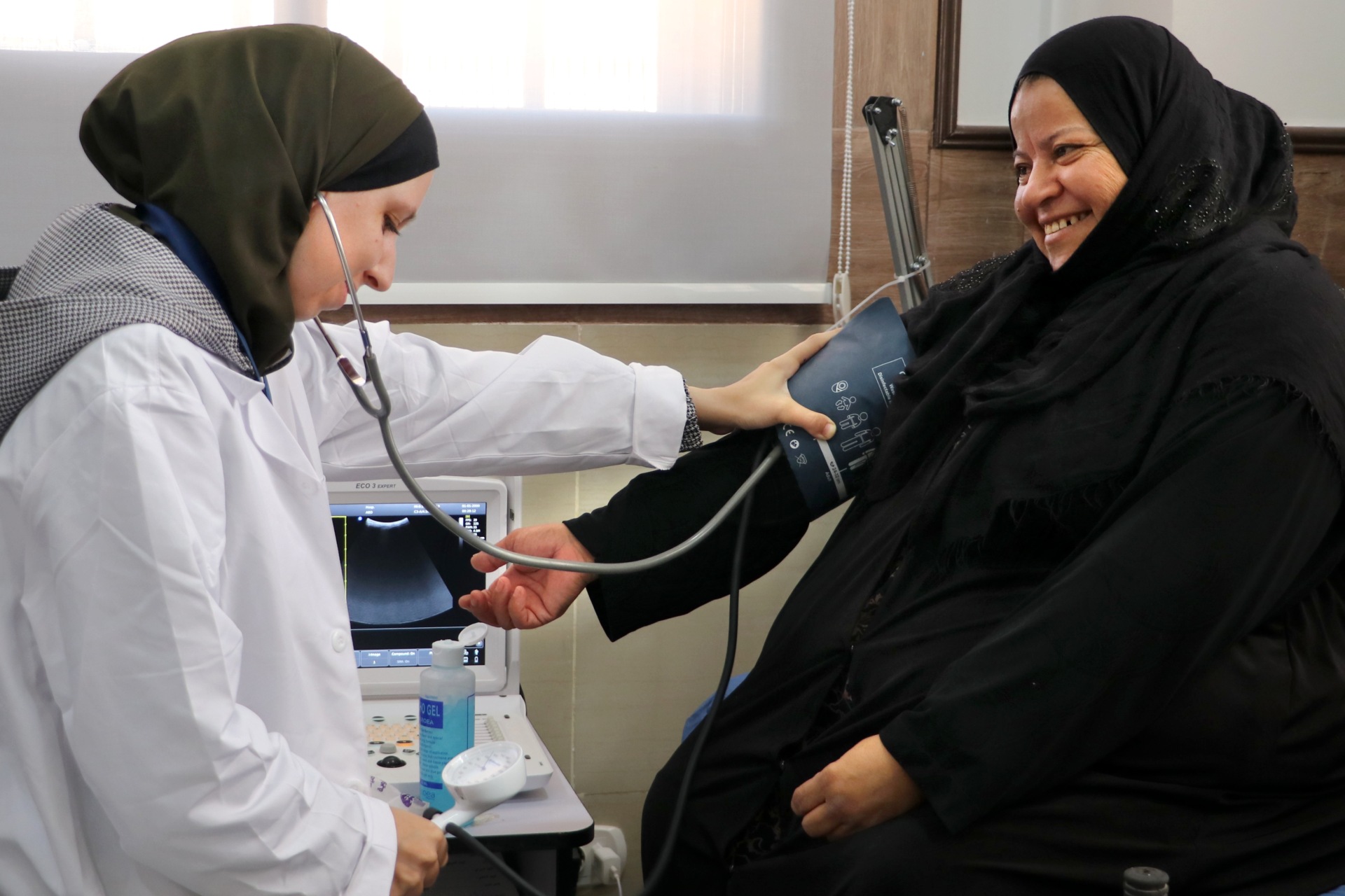 A female health worker takes the blood pressure of a patient.