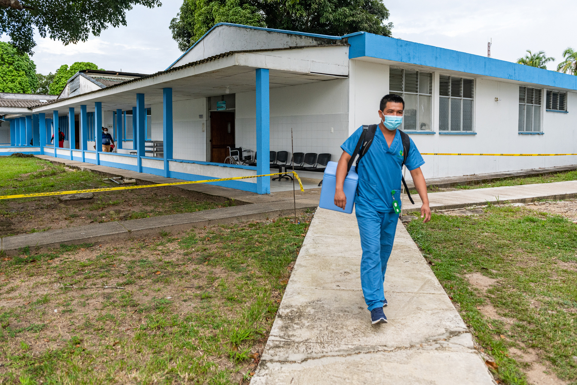 A health worker is carrying a cooler box containing vaccines