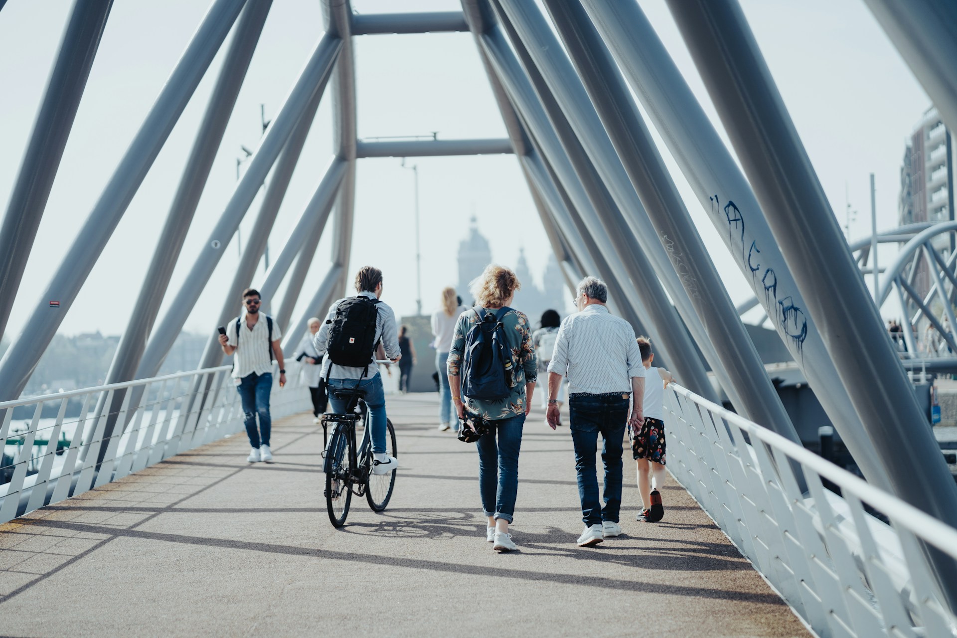 A group of people walking and cycling over a bridge Urban health A group of people walking and cycling over a bridge