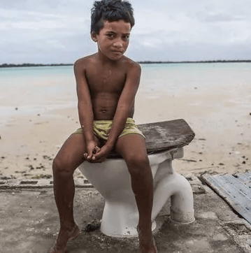 Wash online courses picture of a boy sitting on a toilet placed in a desert landscape