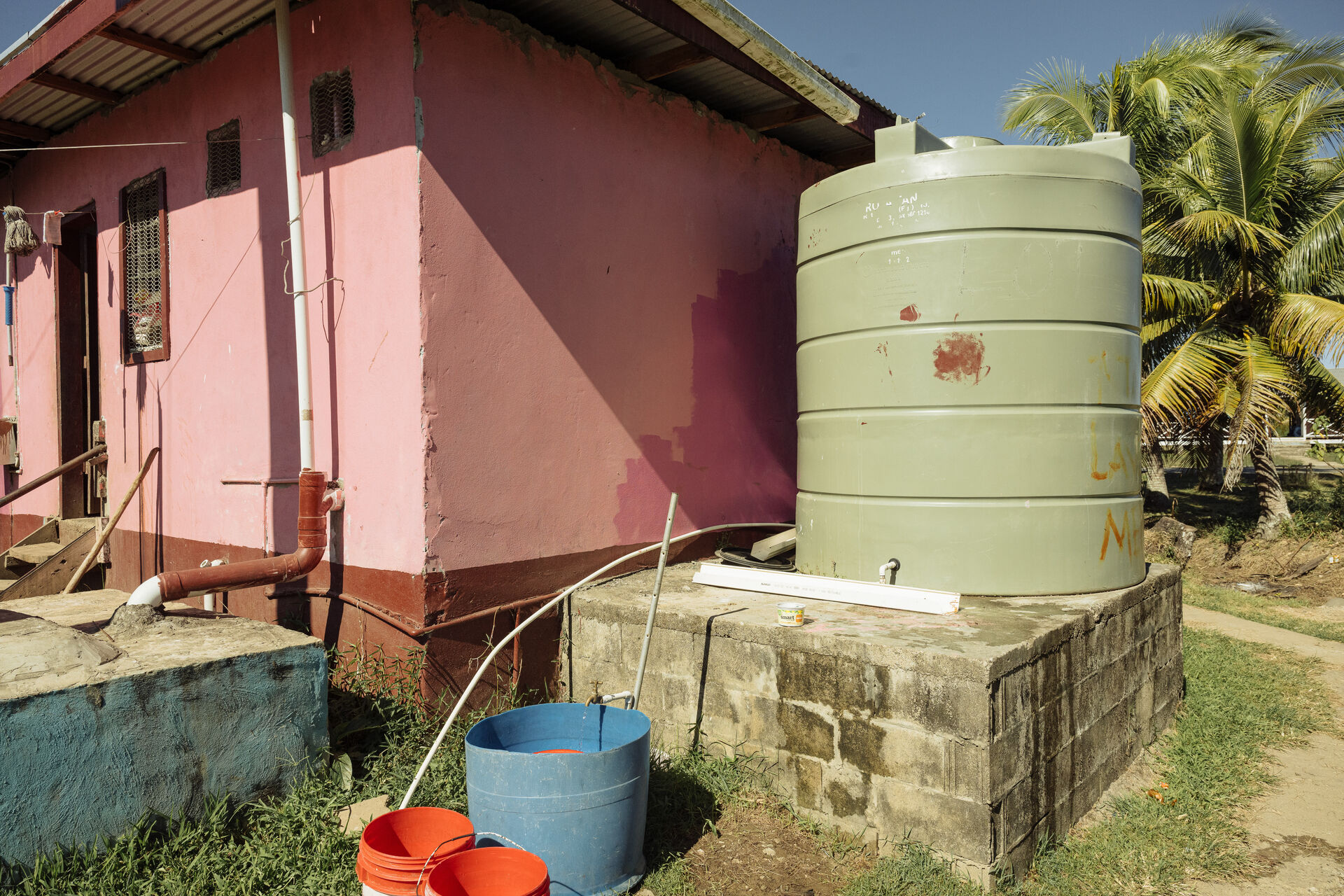 water tank next to a pink house