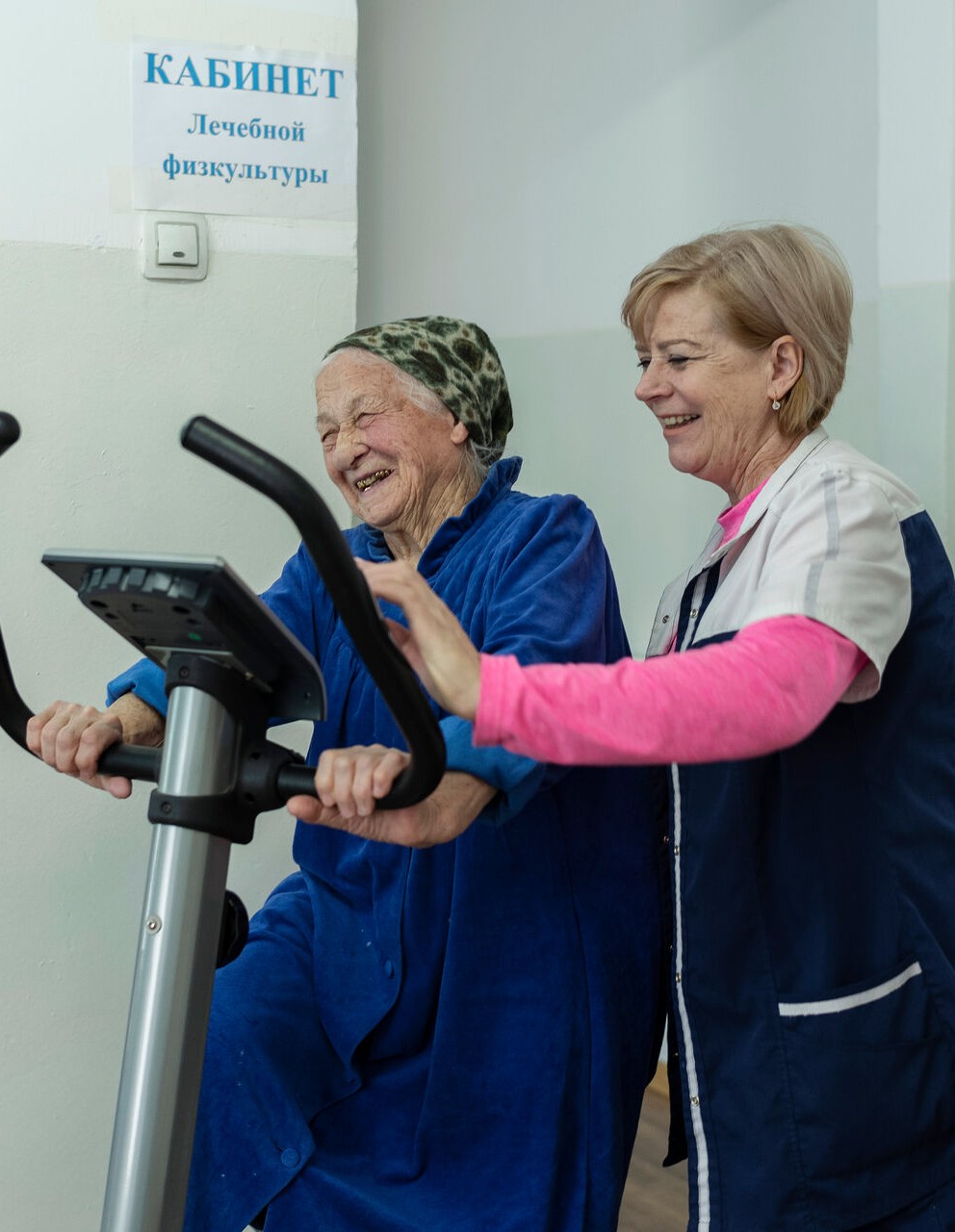 Elderly residents exercise, assisted by a physical therapist
