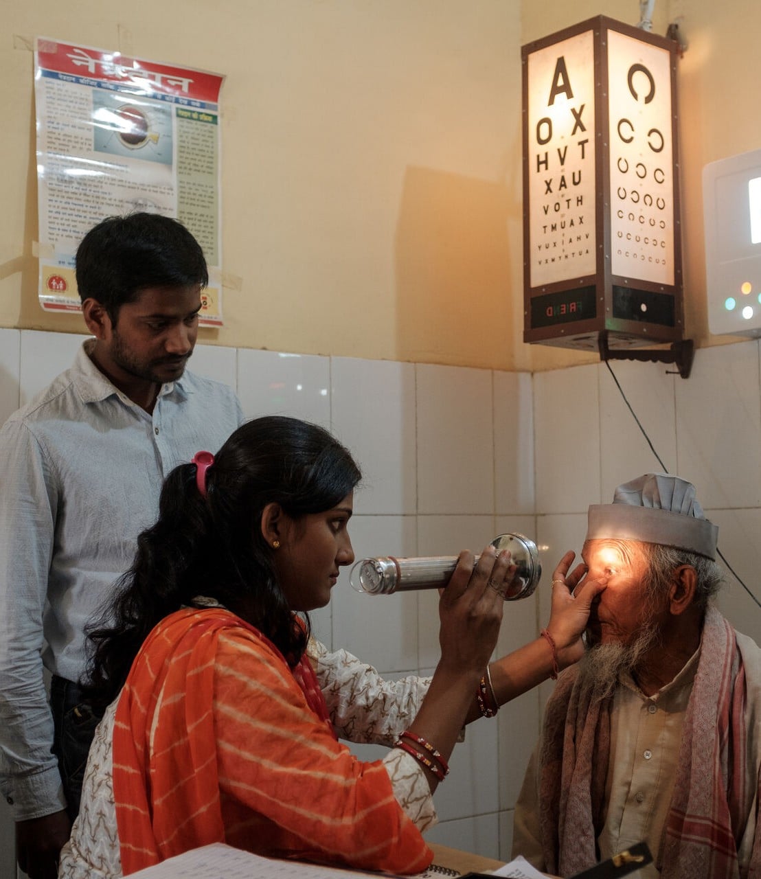 A woman examines with a special torch a man's eye