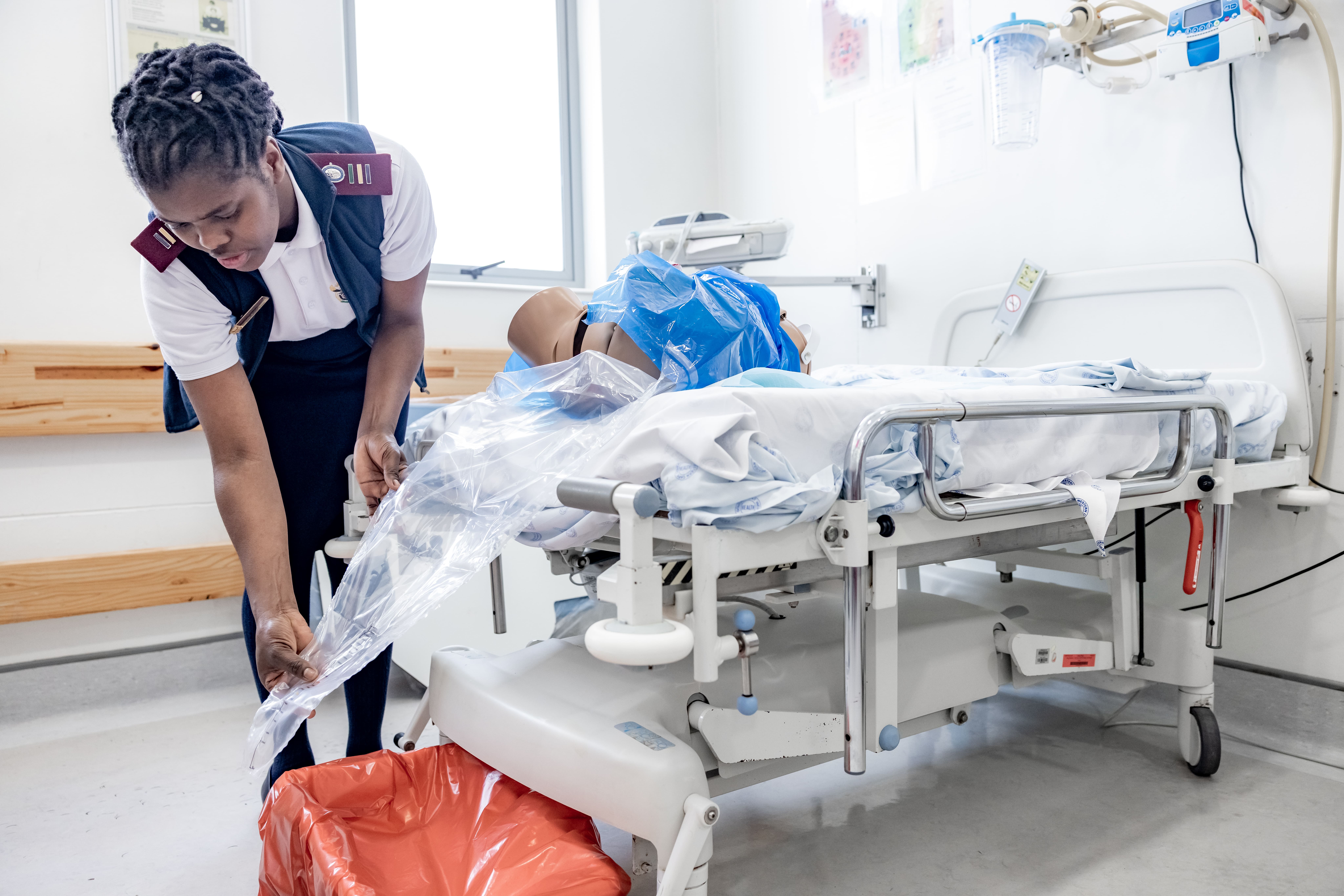 Midwife using a calibrated drape Noxolo Hoga, Advanced Midwife, uses the calibrated drape, a cone shaped plastic sheet with a measurement pouch which is used to accurately collect and quantify blood loss after delivery.