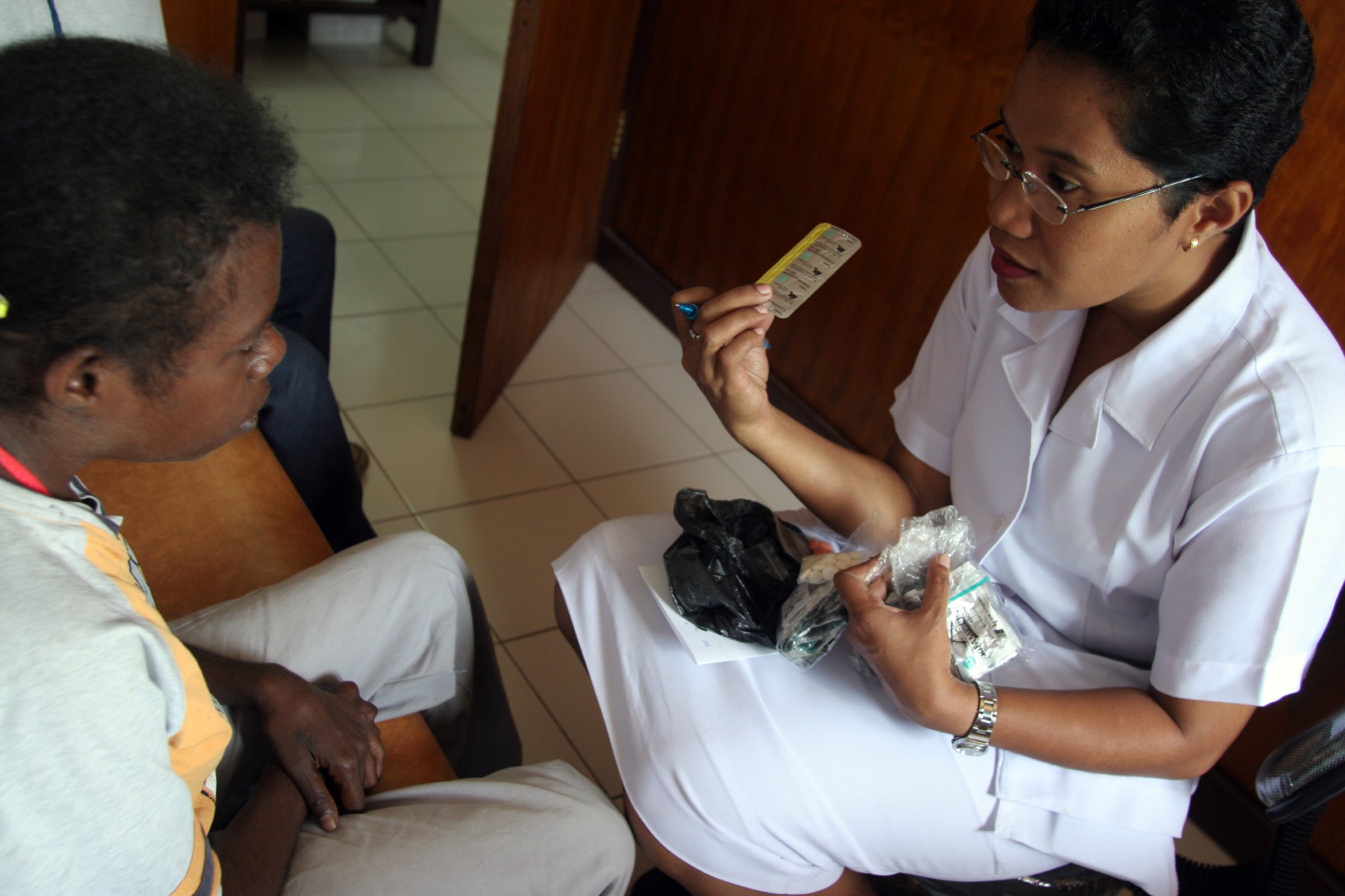 Health worker explains to a new Tuberculosis patient how to take her Tuberculosis medication