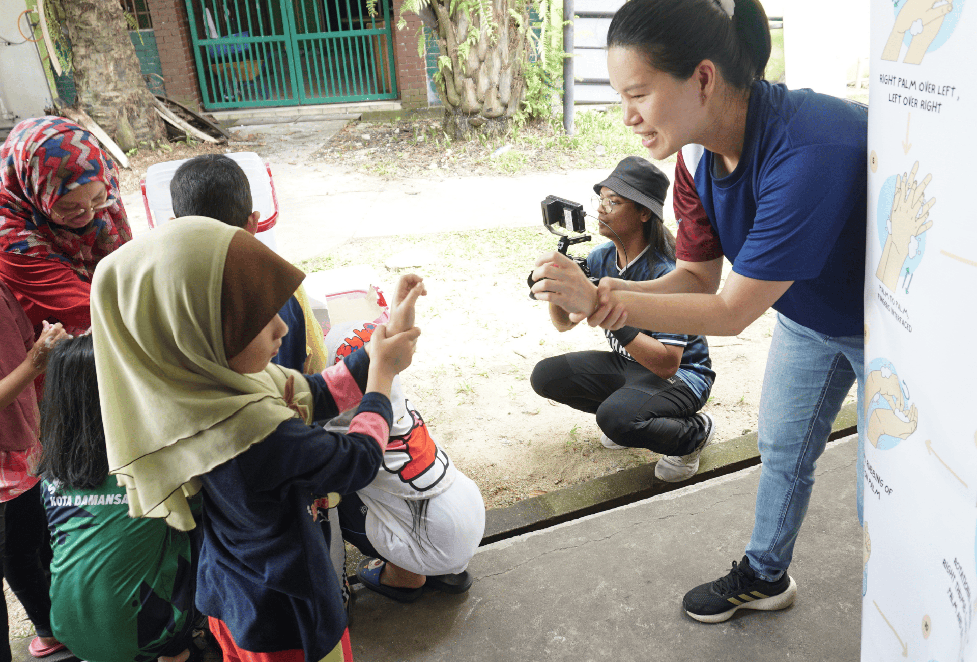 A woman explains handwashing to children