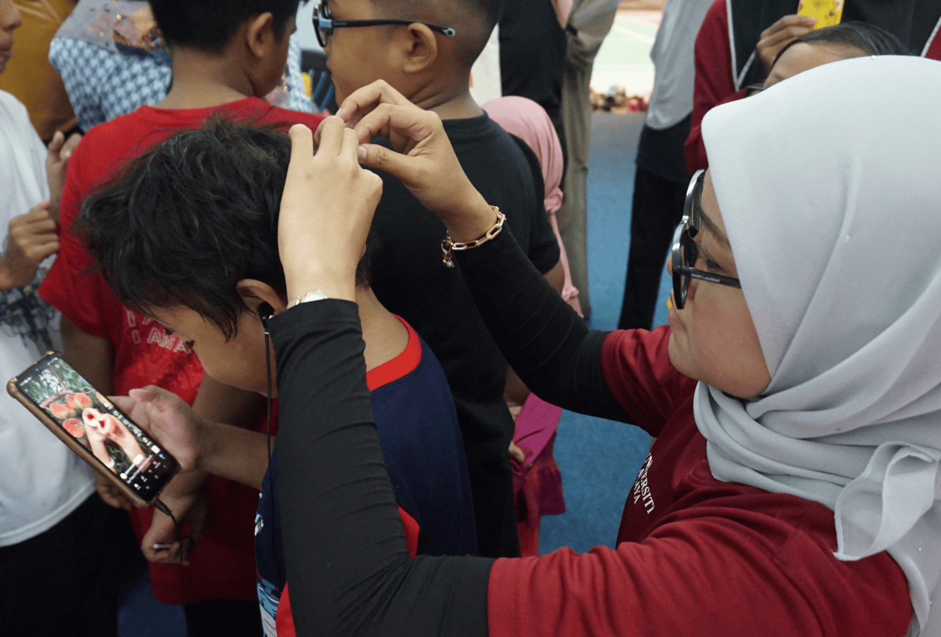 A person examines another person's head for head lice