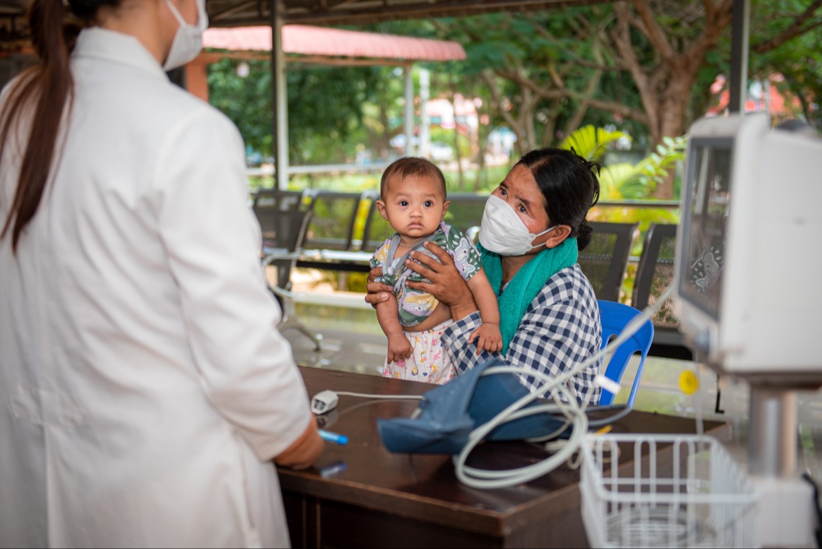 A mother holds her baby during a health check-up