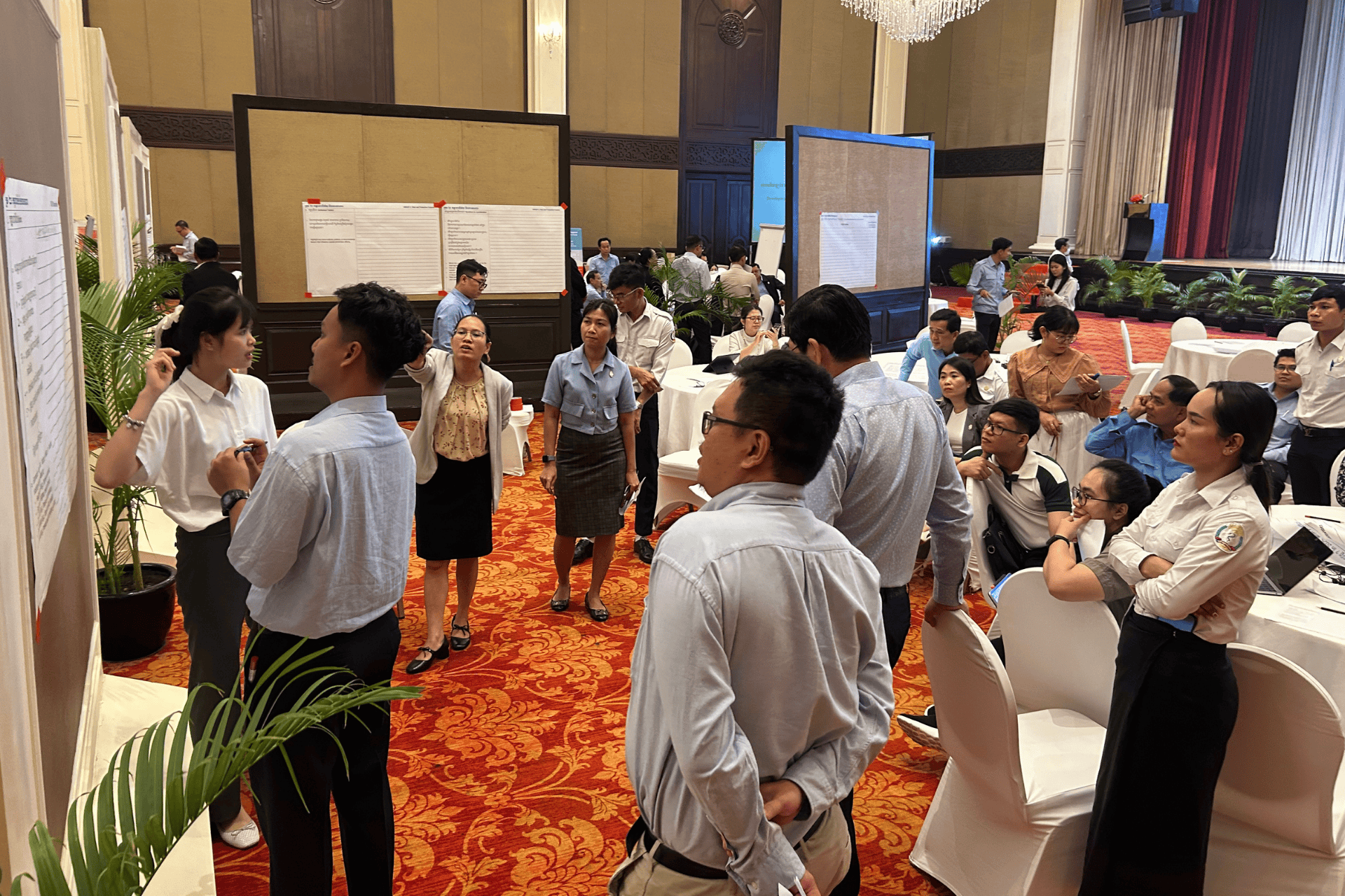 Workshop participants in Cambodia look at a sheet of paper mounted on a wall
