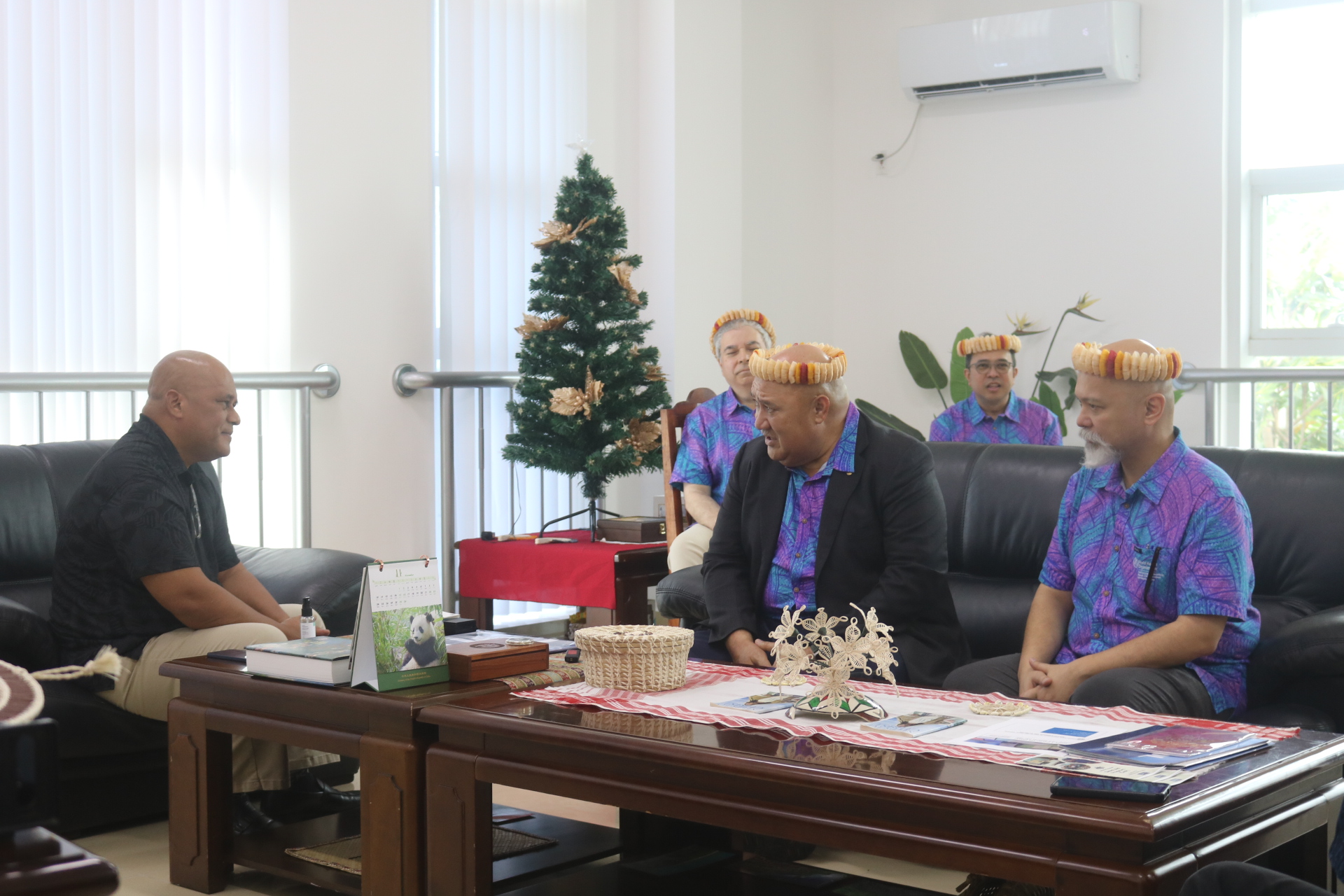 Three people in a meeting in an office in Micronesia