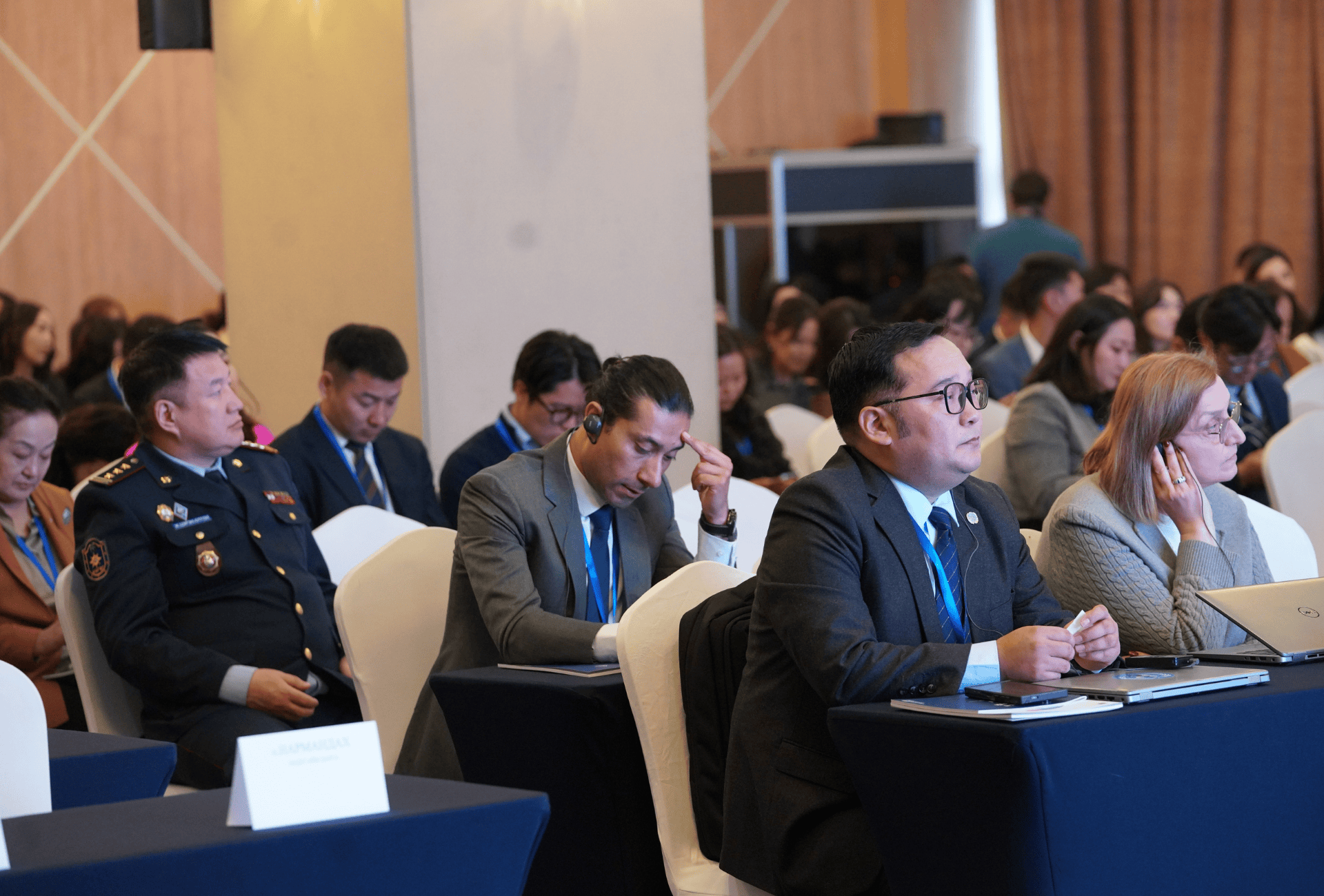 A group of people in a conference sitting on tables