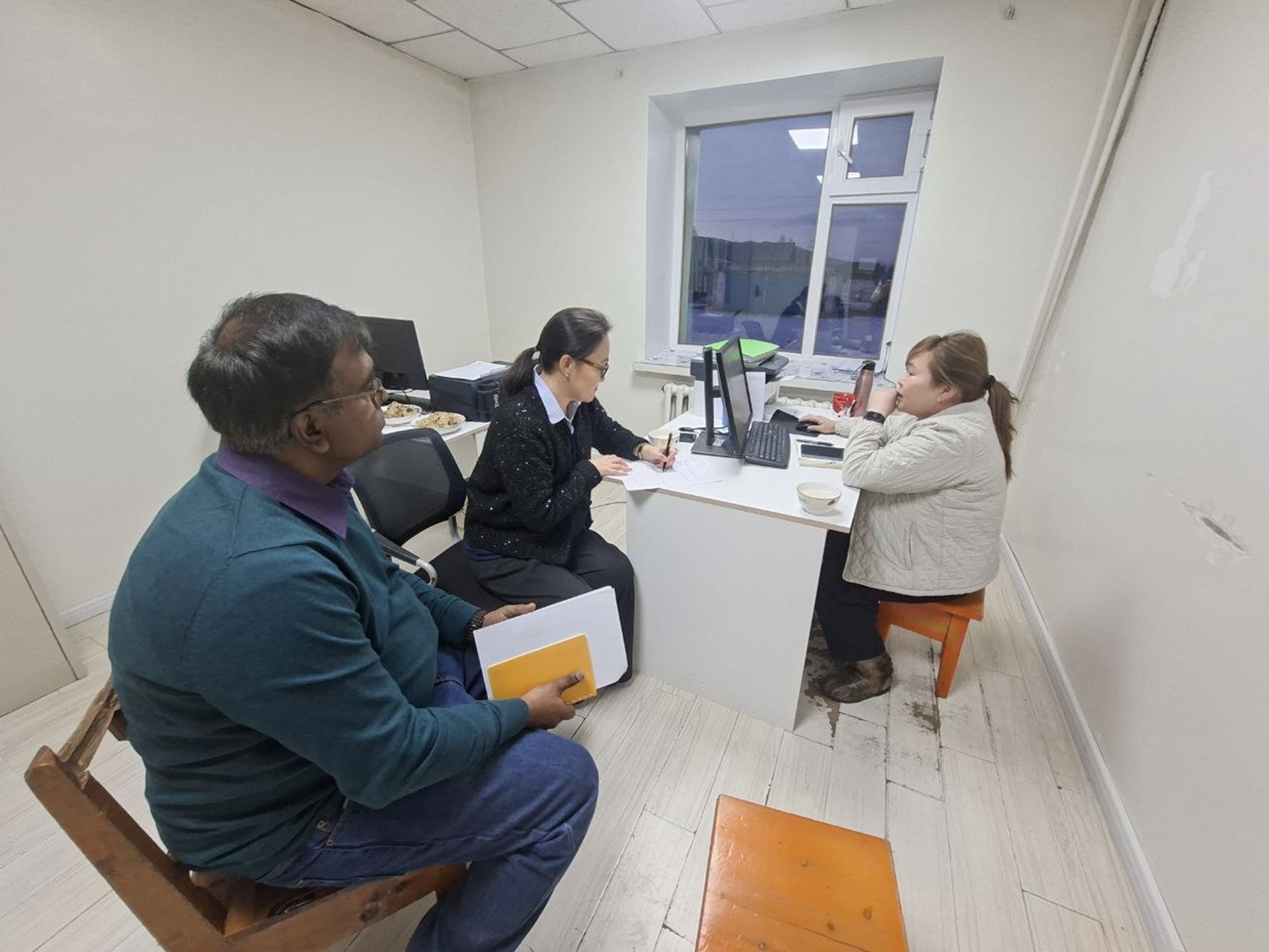 Three people inside a health facility in Mongolia reviewing polio records