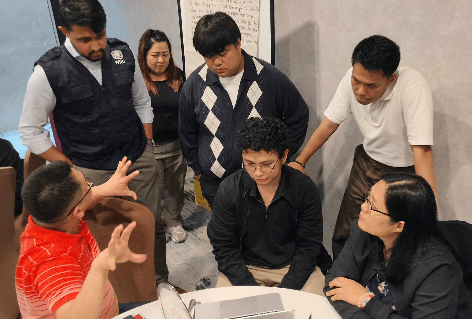 A group of people discusses emergency preparedness in an emergency simulation training in the Philippines