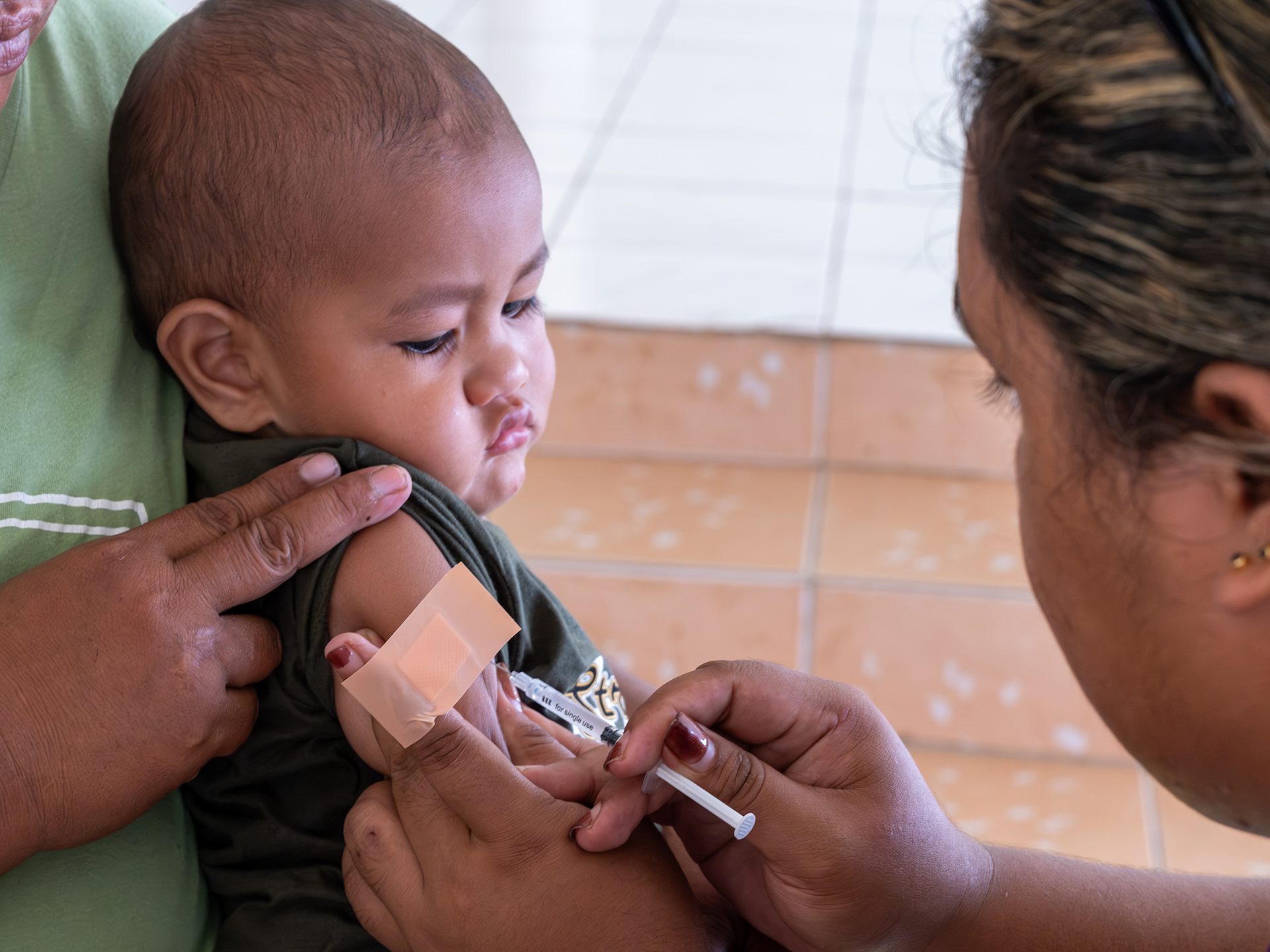 A nurse gives a vaccine to a child during an outreach activity.