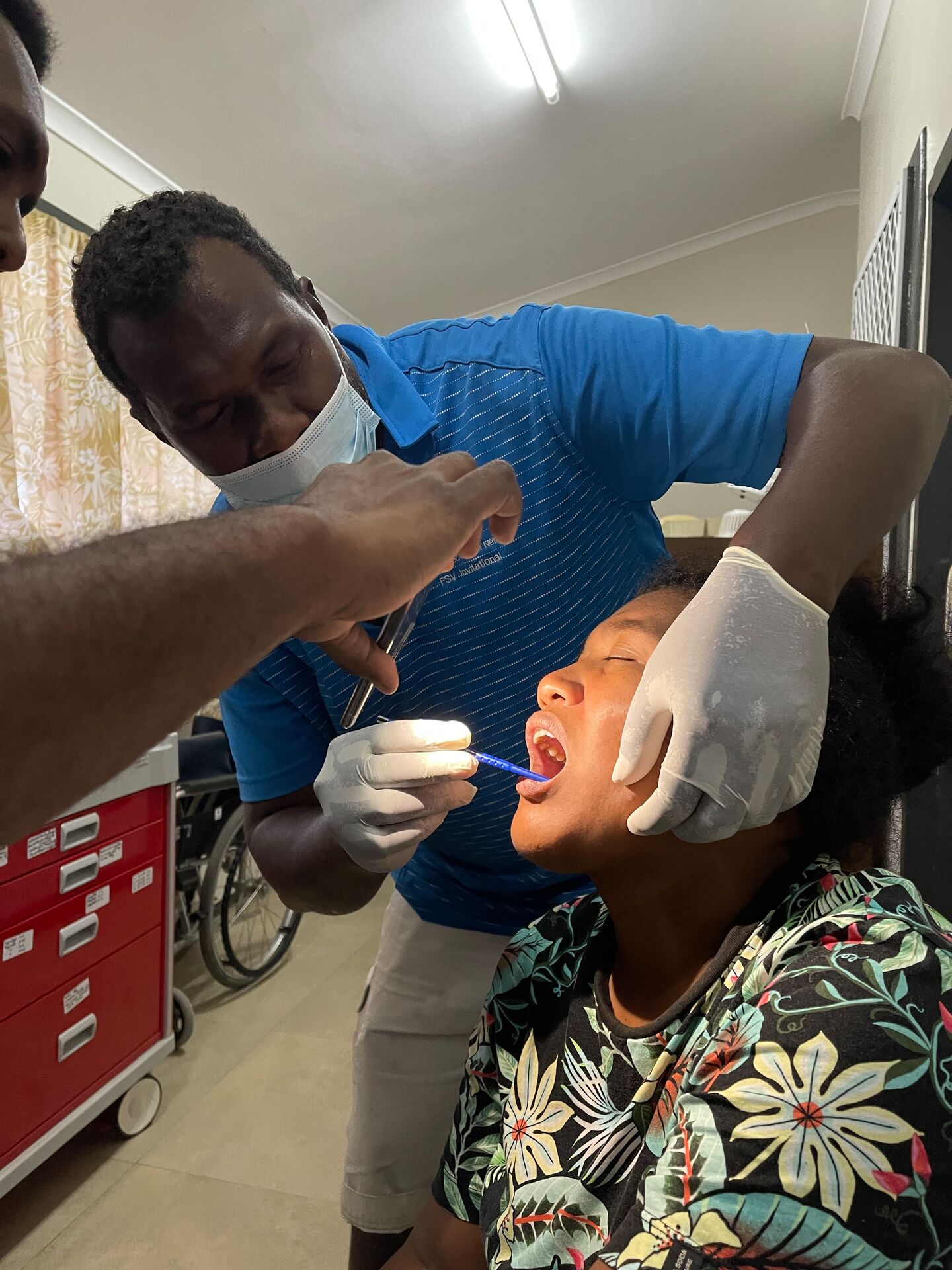 A health worker examines a patient's mouth