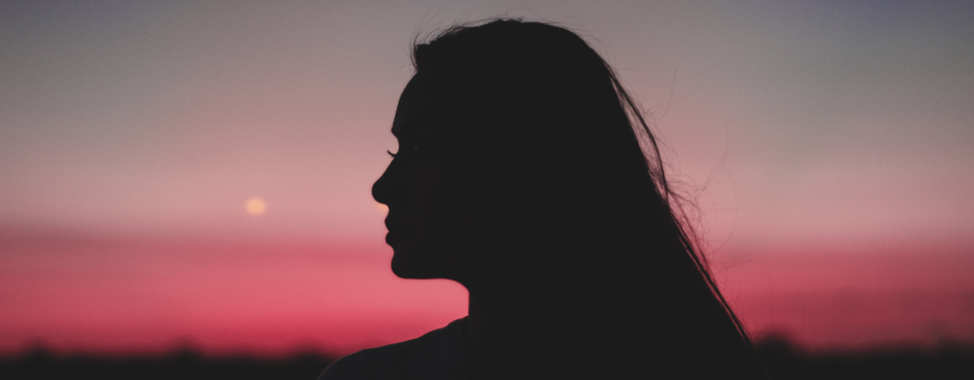 Silhouette of a woman against a sunset