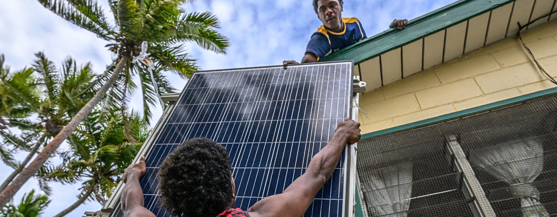 Two women installing solar panels in a health facility