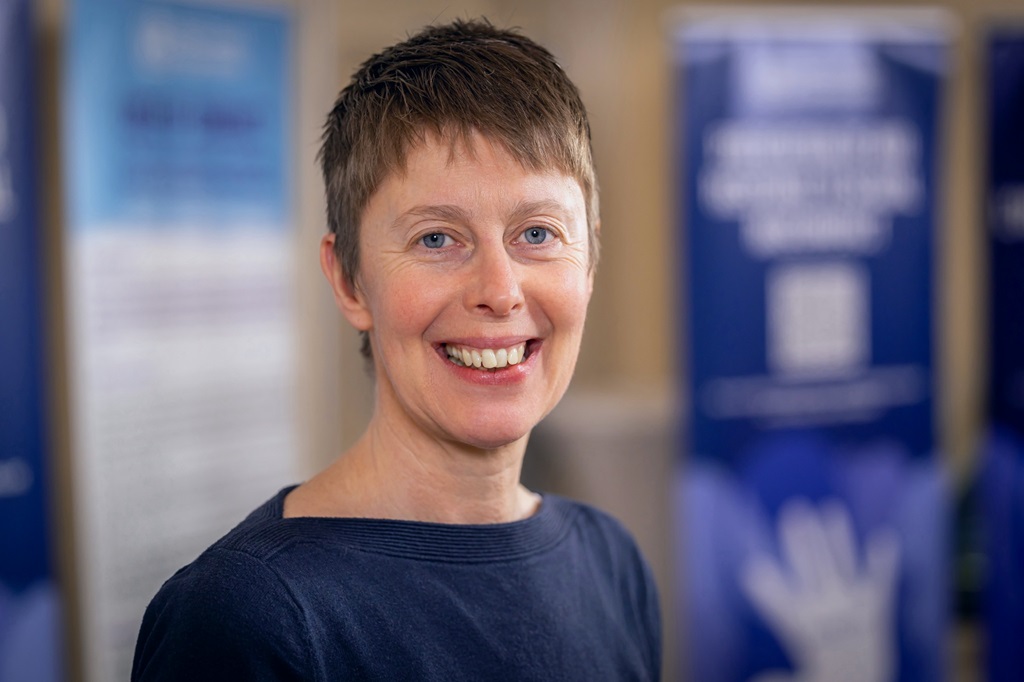 Portrait photo of a woman with short hair and smiling towards the camera.