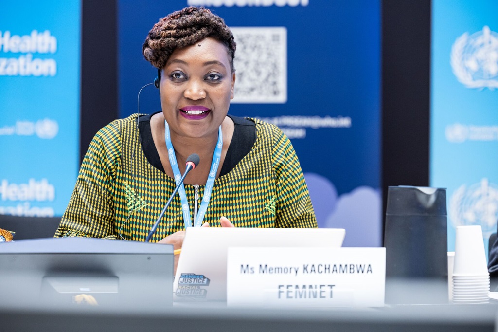 A close up of a woman at a conference, talking into the microphone.