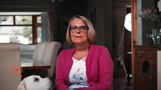 Woman sitting on a chair looking into the camera.