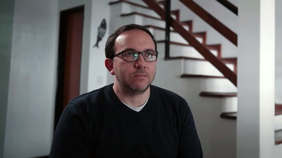 Video snapshot of a man in a house looking afar.