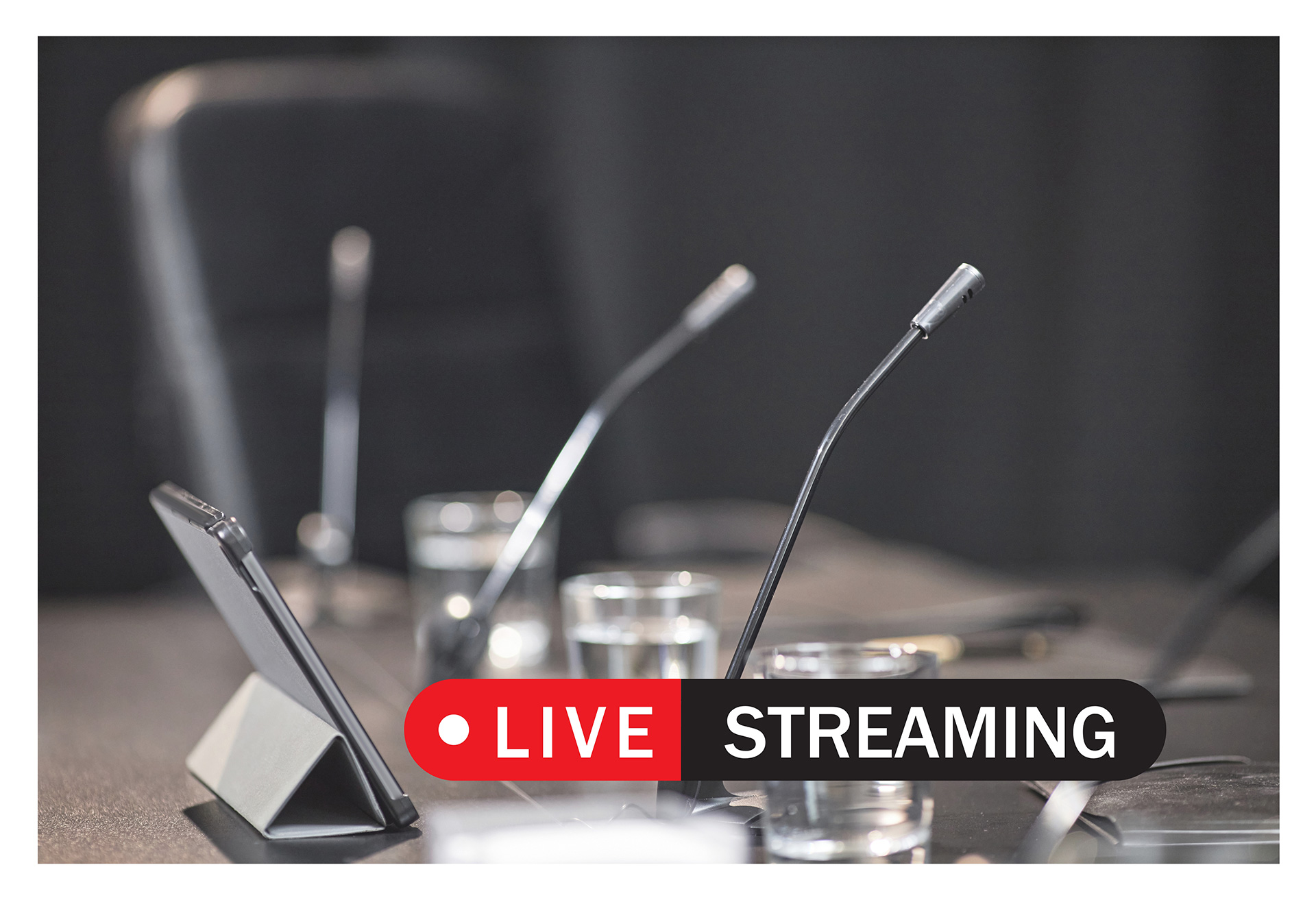 live streaming tile Tile showing 'Live Streaming', over a photo of conference microphones.