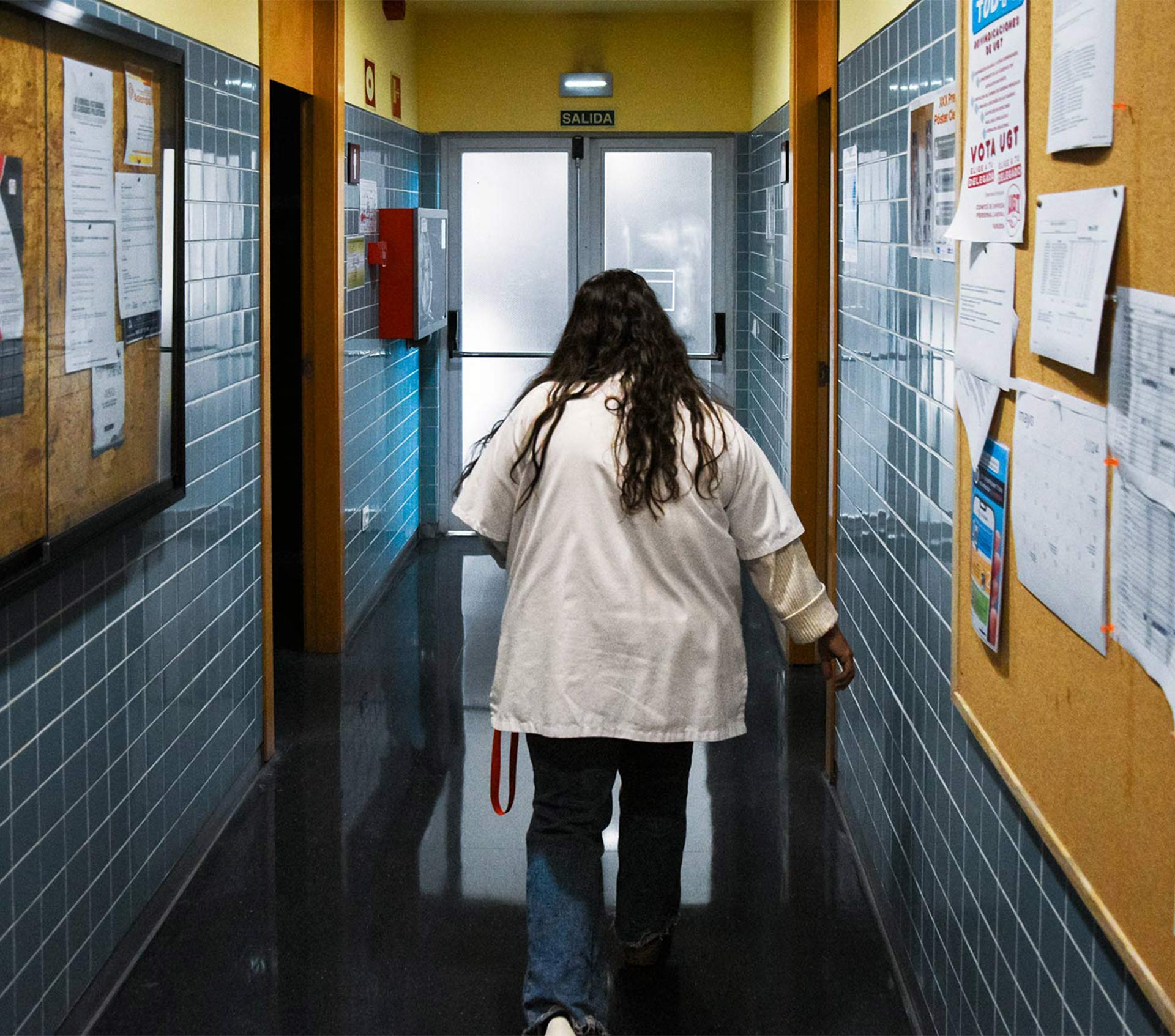 A nurse walking down a corridor in a health centre.
