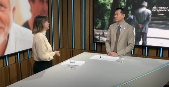 Two presenters talk at a studio desk
