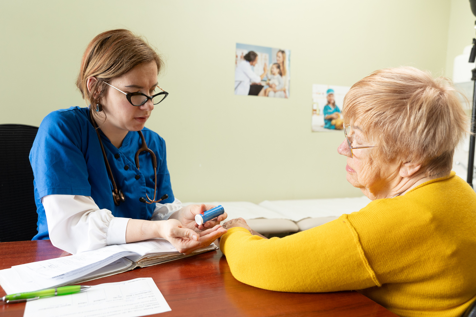 Une femme âgée est assise dans un cabinet médical à Riga, en conversation avec son médecin.